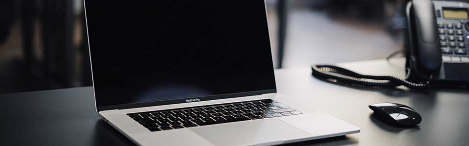 laptop on desk beside phone